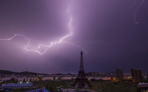 Lightning bolt streaks across the sky above a replica of the Eiffel Tower at the Tianducheng development in Hangzhou